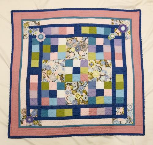 Small quilt with pink border and applique